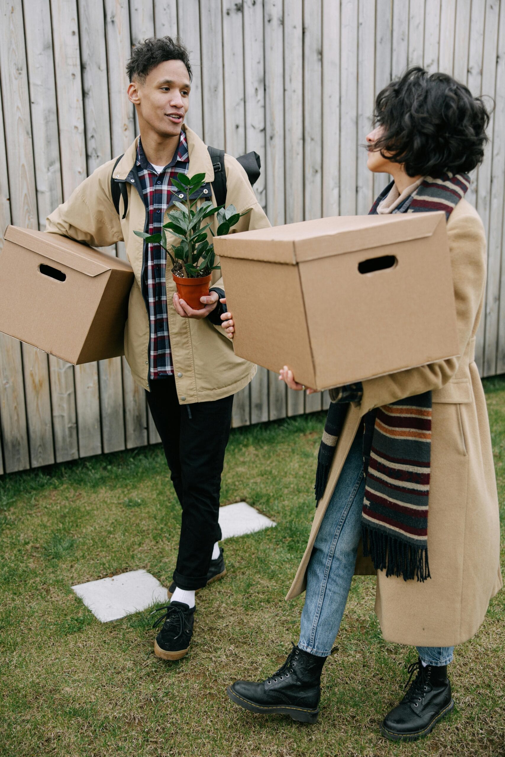 Young couple carrying boxes while moving into a new home.