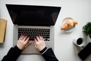 A person typing on a laptop at a clean, organized desk