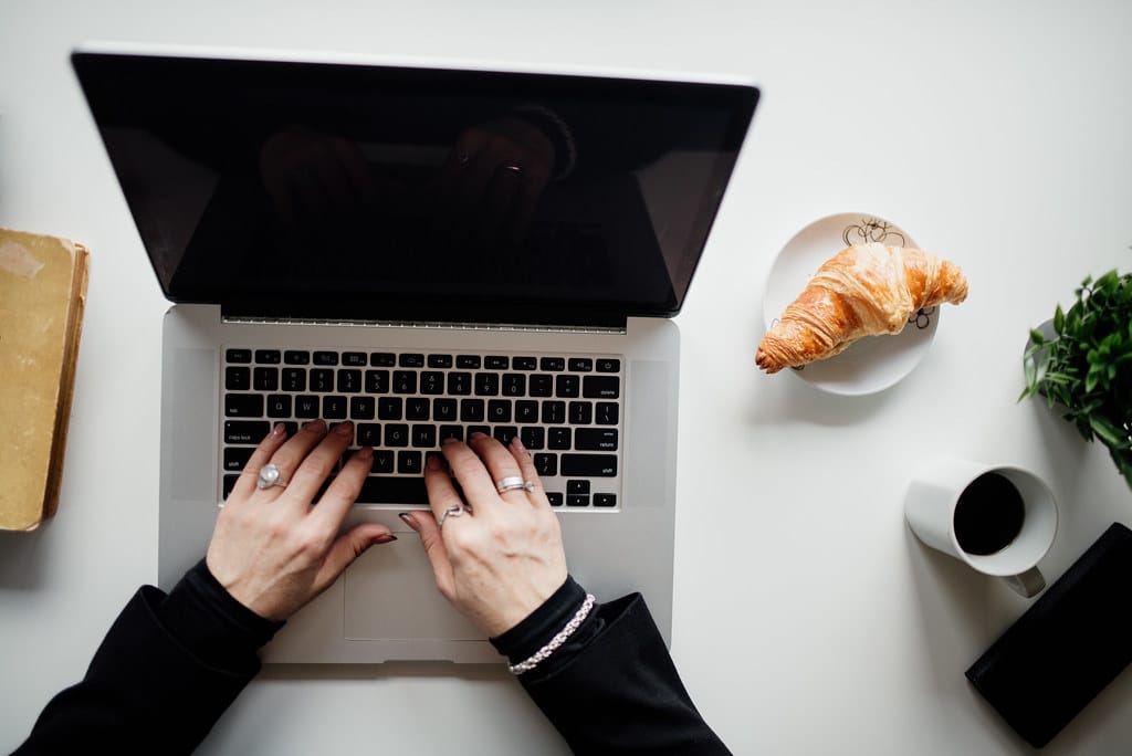 A person typing on a laptop at a clean, organized desk