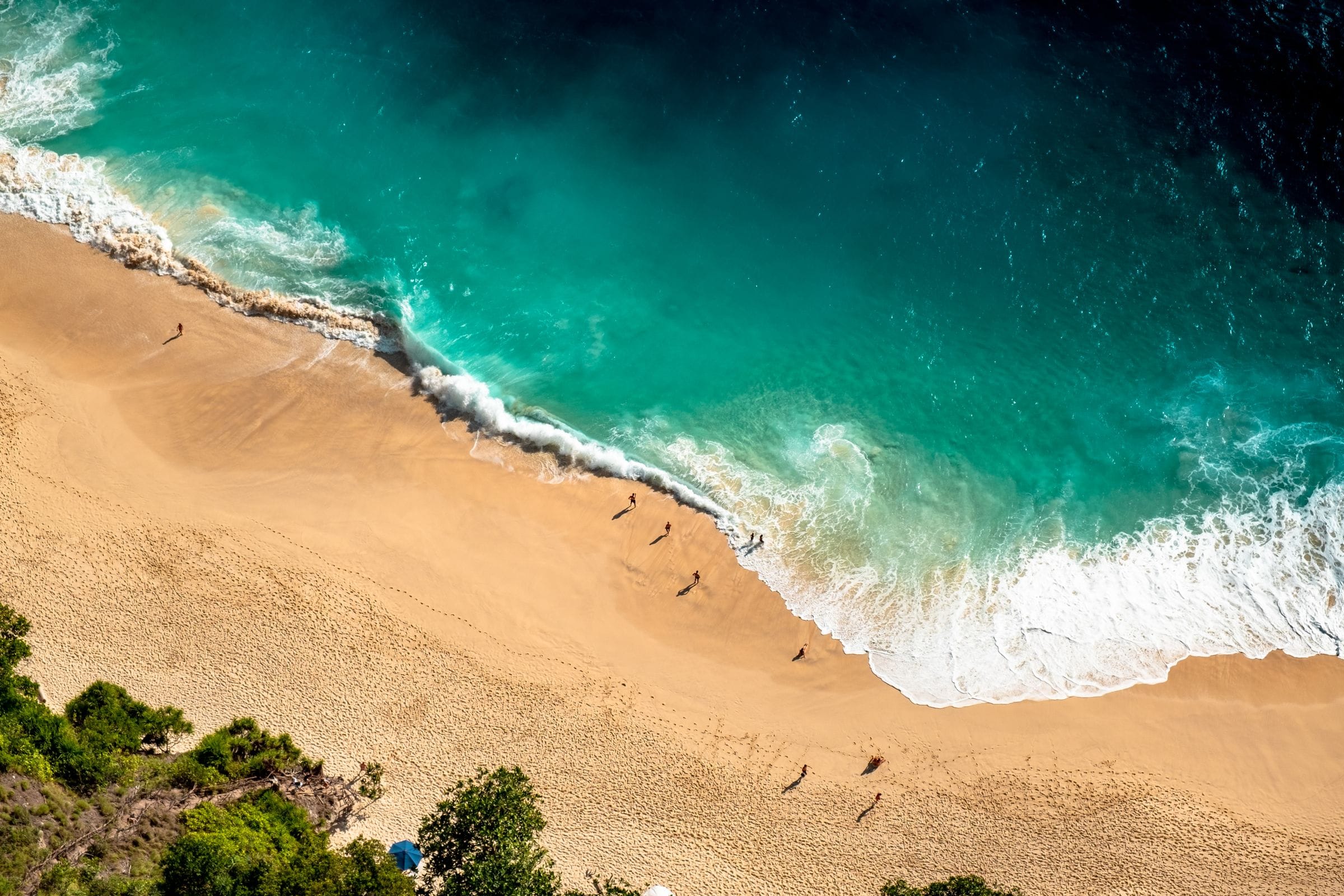 Aerial view of waves rolling onto a golden sandy beach